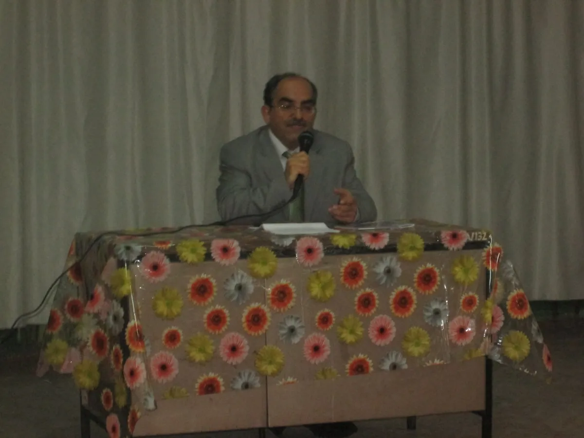 Yazar Cemalettin Yazıcı bir okulda mikrofonla öğrencilere hitap ediyor.